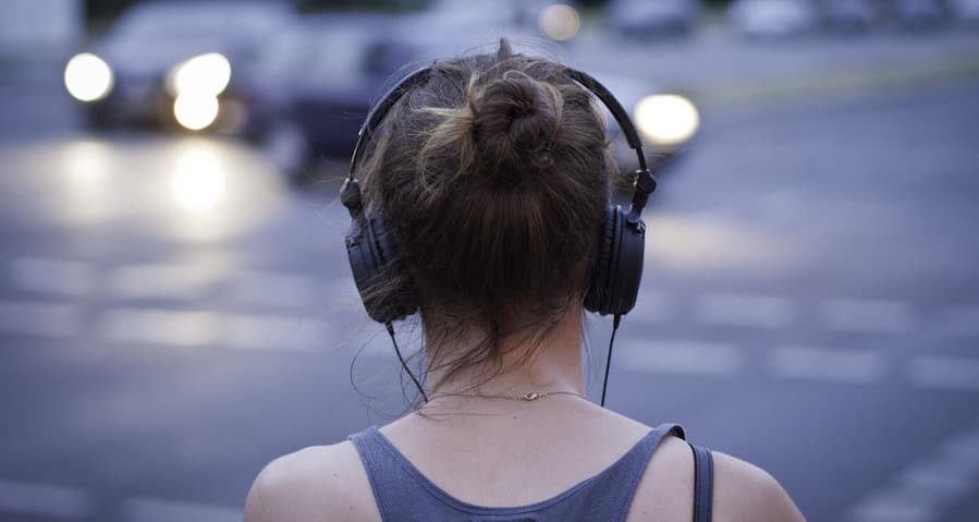 une femme écoute un podcast ou un documentaire audio au casque dans la rue