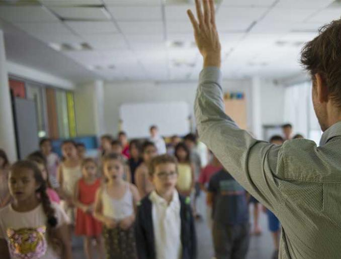 les enfants chantent sous la direction d'un musicien intervenant